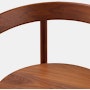 A close up detail shot of the wood seat and backrest of a Comma Chair with arms.