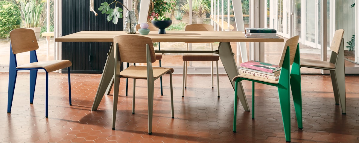 Prouve EM Table surrounded by Prouve Standard SP Chairs in a dining room setting