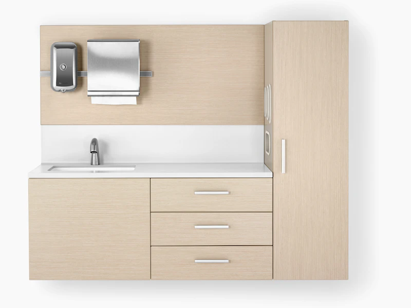 Mora casework in an ash finish and a white solid surface top and sink. The casework is wall-hung and has 3 drawers and one storage tower.