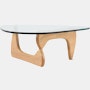 A Noguchi Table with light wood base and glass top.
