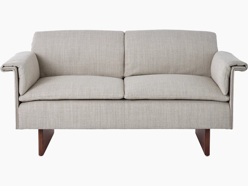 Mantle Two Seater Sofa in Capri Stone with Walnut Wood Base, viewed from the front.