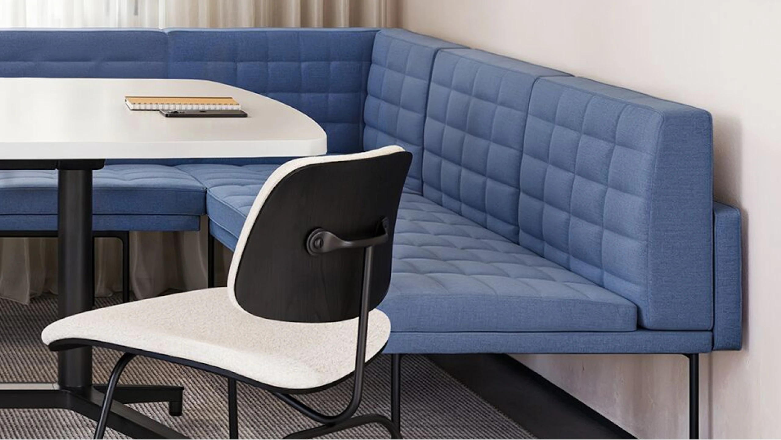 A blue Geiger Tuxedo Component Lounge, black and white Knoll Grasshopper Table, and white Knoll Bertoia chair used in a group conference room setting that considers the wellbeing of employees