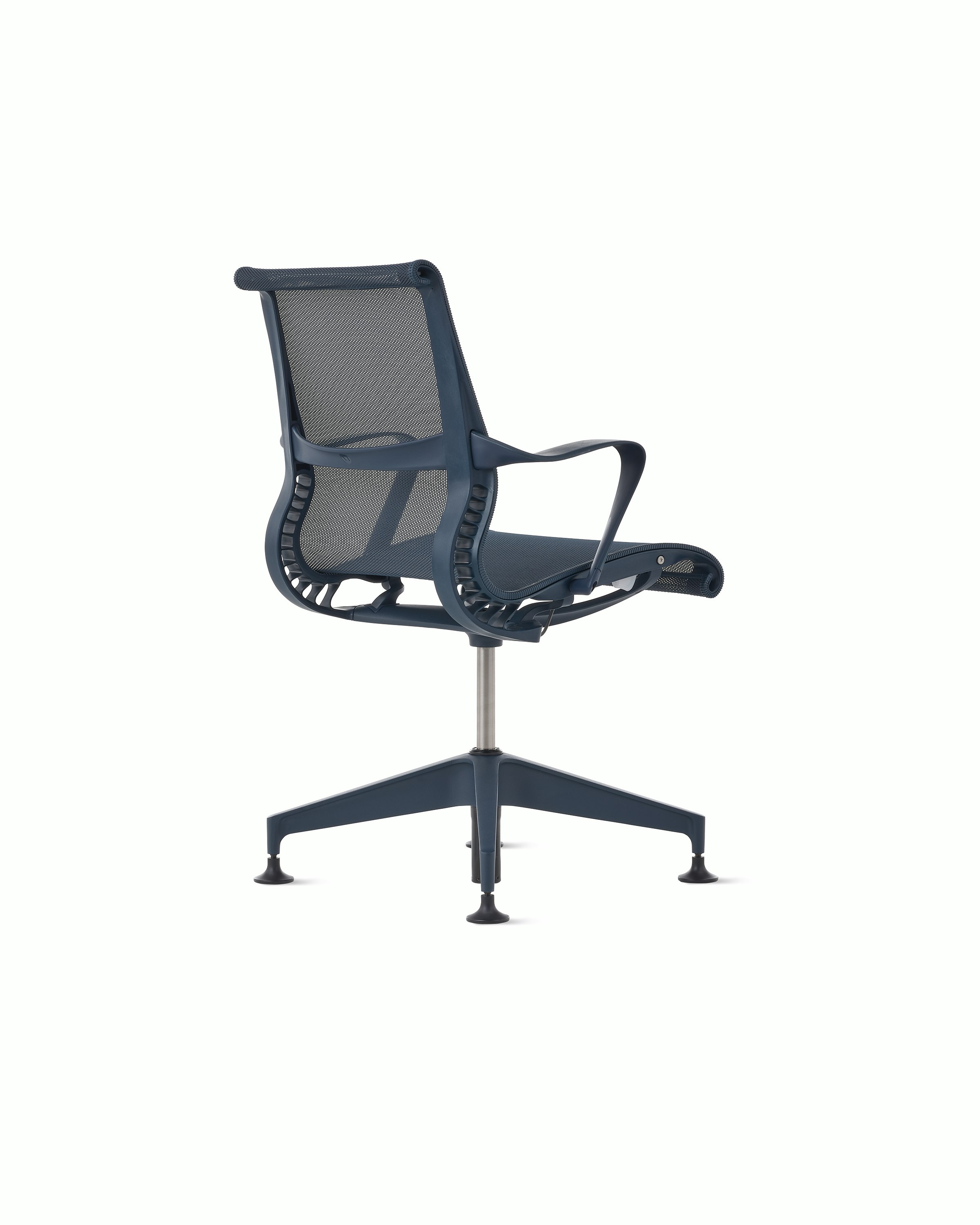 Rear angle view of a Setu side chair with fixed arms in dark blue.