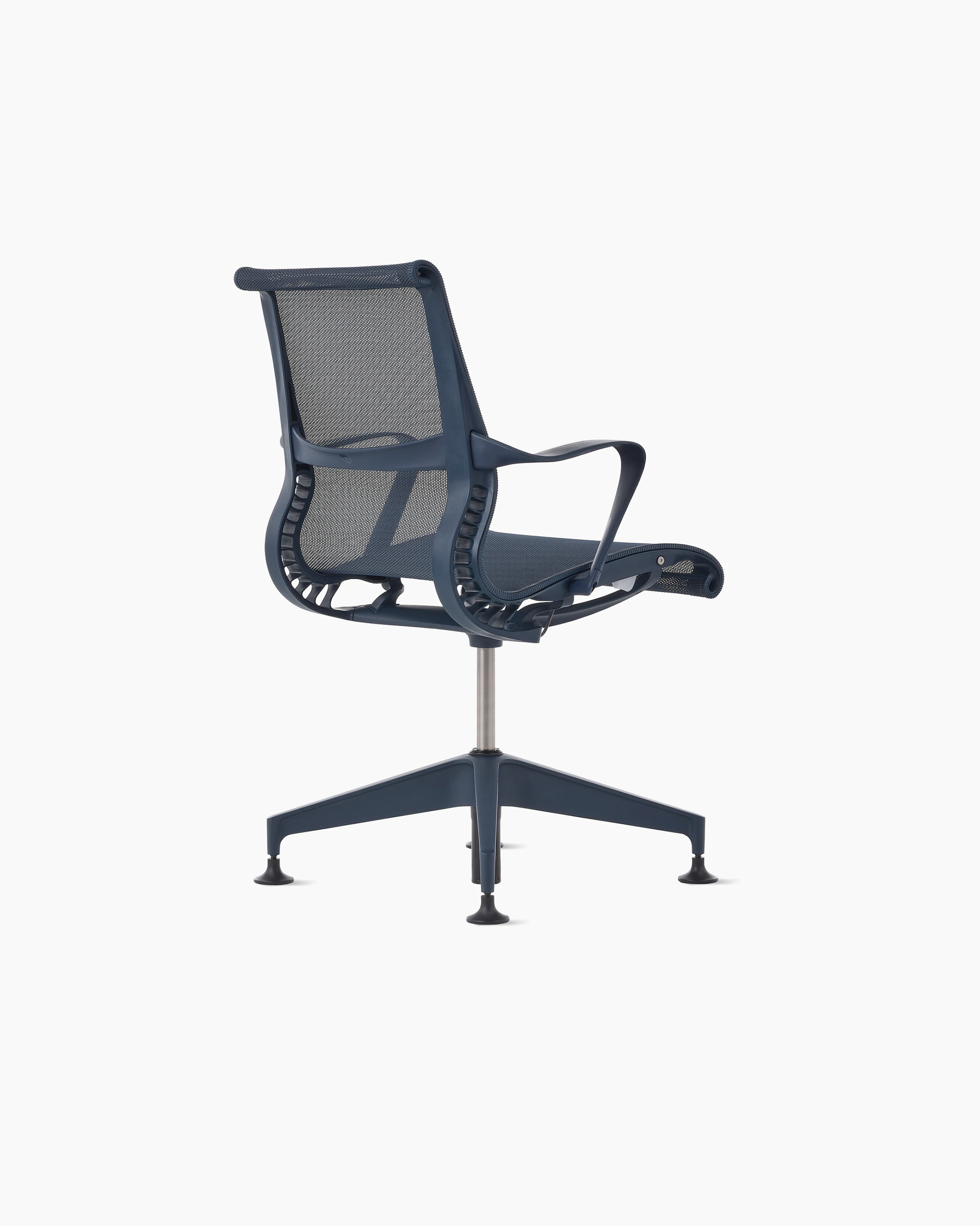 Rear angle view of a Setu side chair with fixed arms in dark blue.