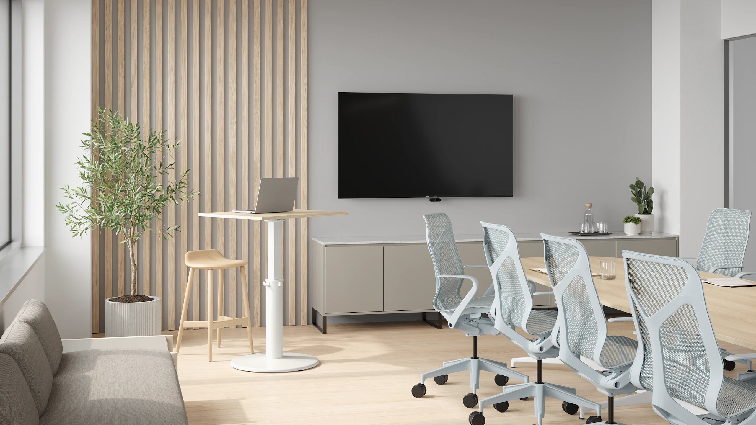 Conference room with OE1 Sit-to-Stand Table, conference table and light blue Cosm chairs.
