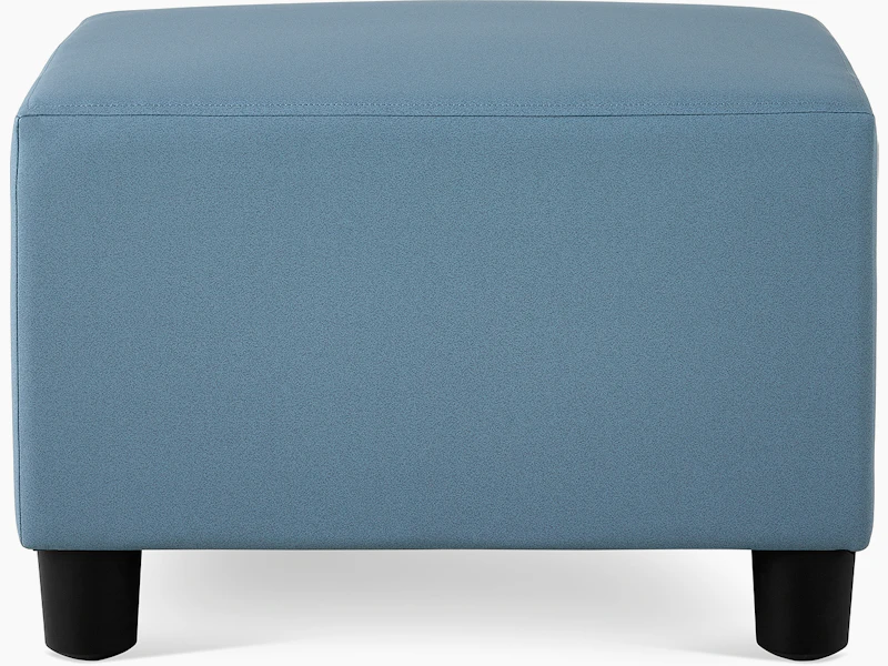 A Swoop Ottoman in blue upholstery.