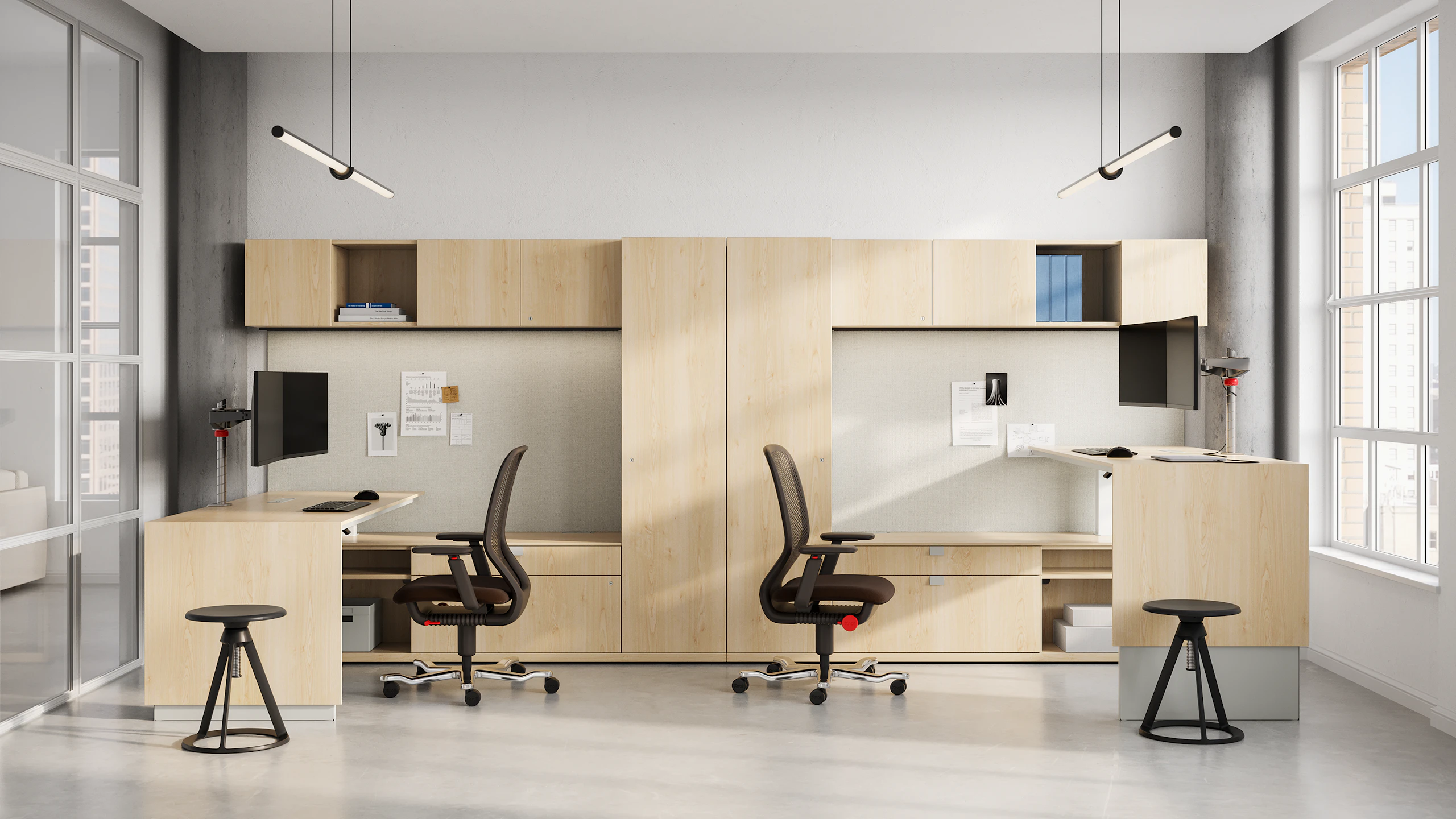 A shared private office featuring a height-adjustable tables, workwalls, overheads and credenzas in a blonde maple premium wood veneer finish.