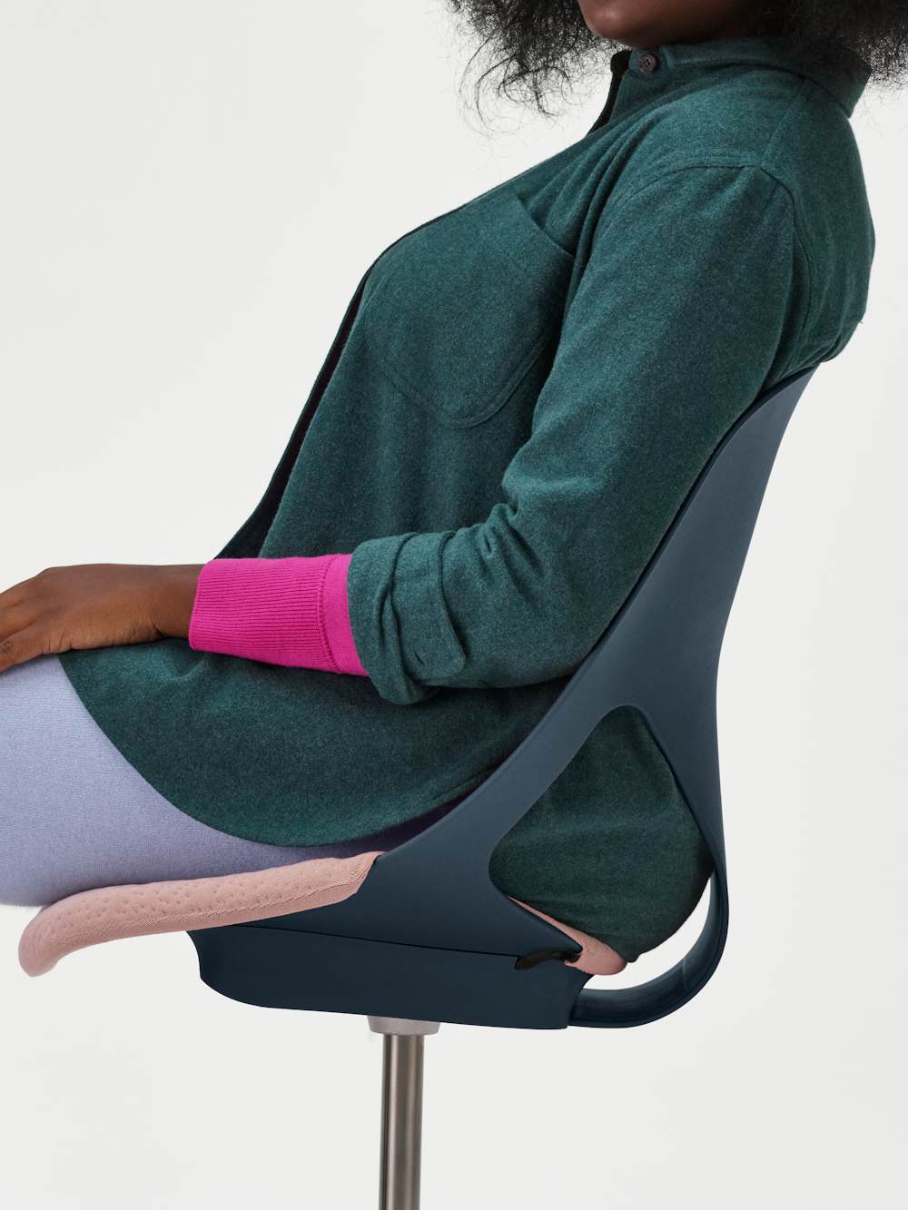 A woman sitting in a red Zeph chair without arms and pink seat cover.