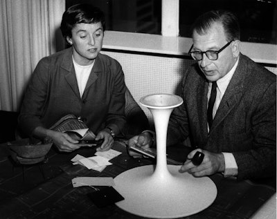 Florence Knoll and Eero Saarinen inspecting the base of a Saarinen Table.