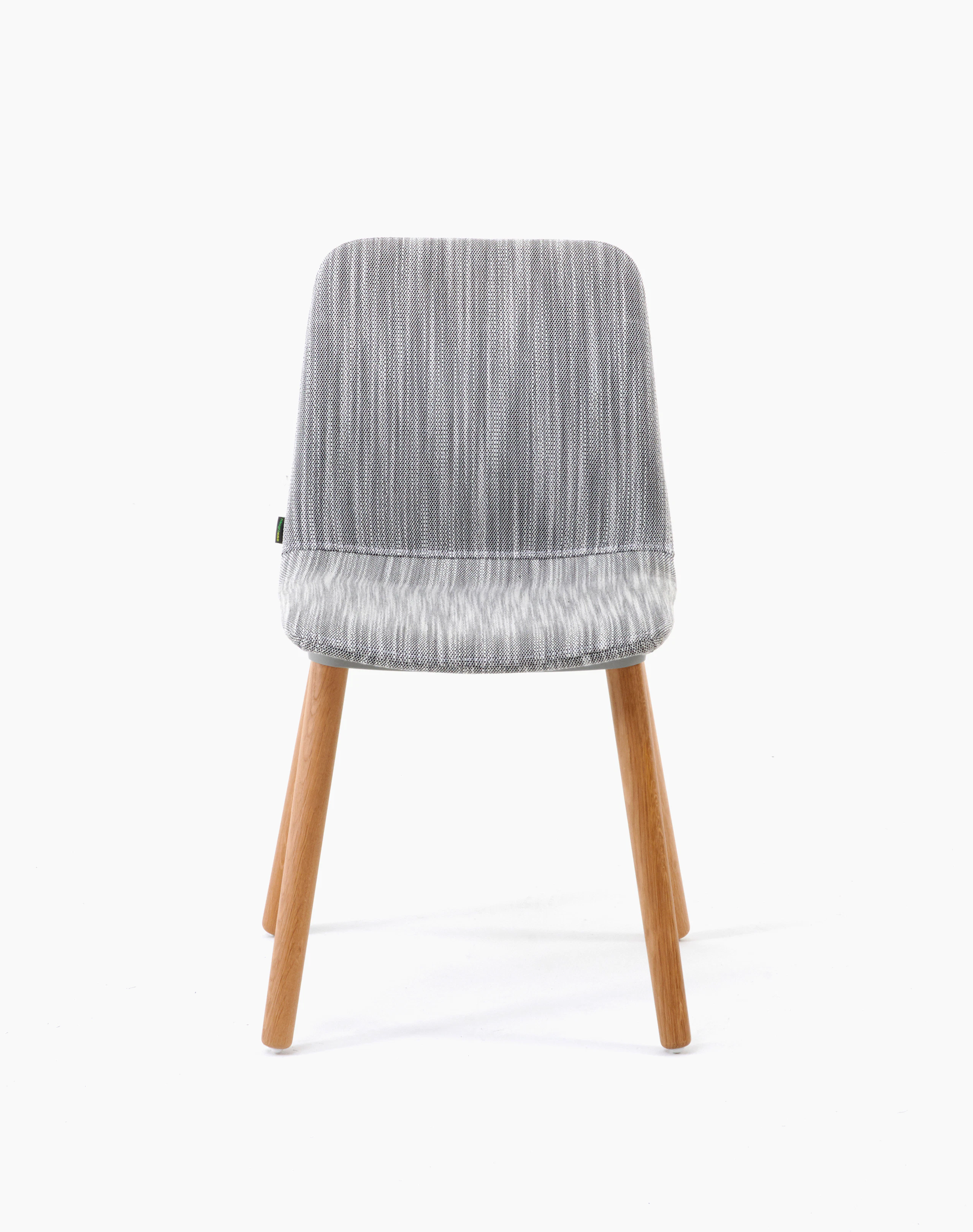 White sweep shot of chair upholstered in light grey fabric on oak dowel base.
