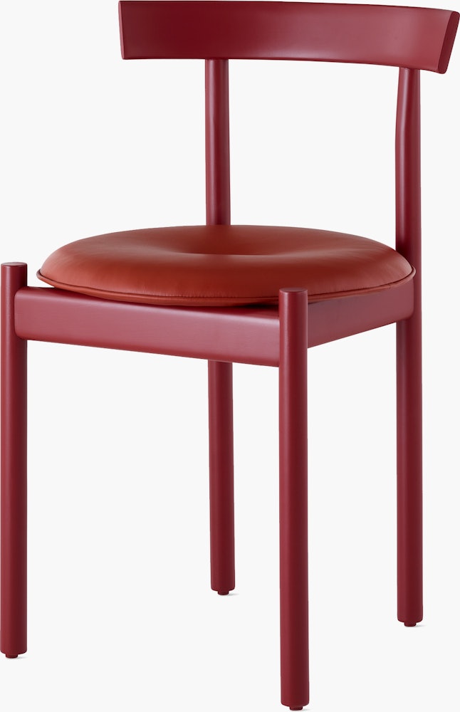 A red Comma Chair with a seat pad, viewed from the front at an angle.