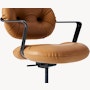 Detail view of a Morrison Hannah chair with a black frame and base with fixed arms and light brown leather upholstery.