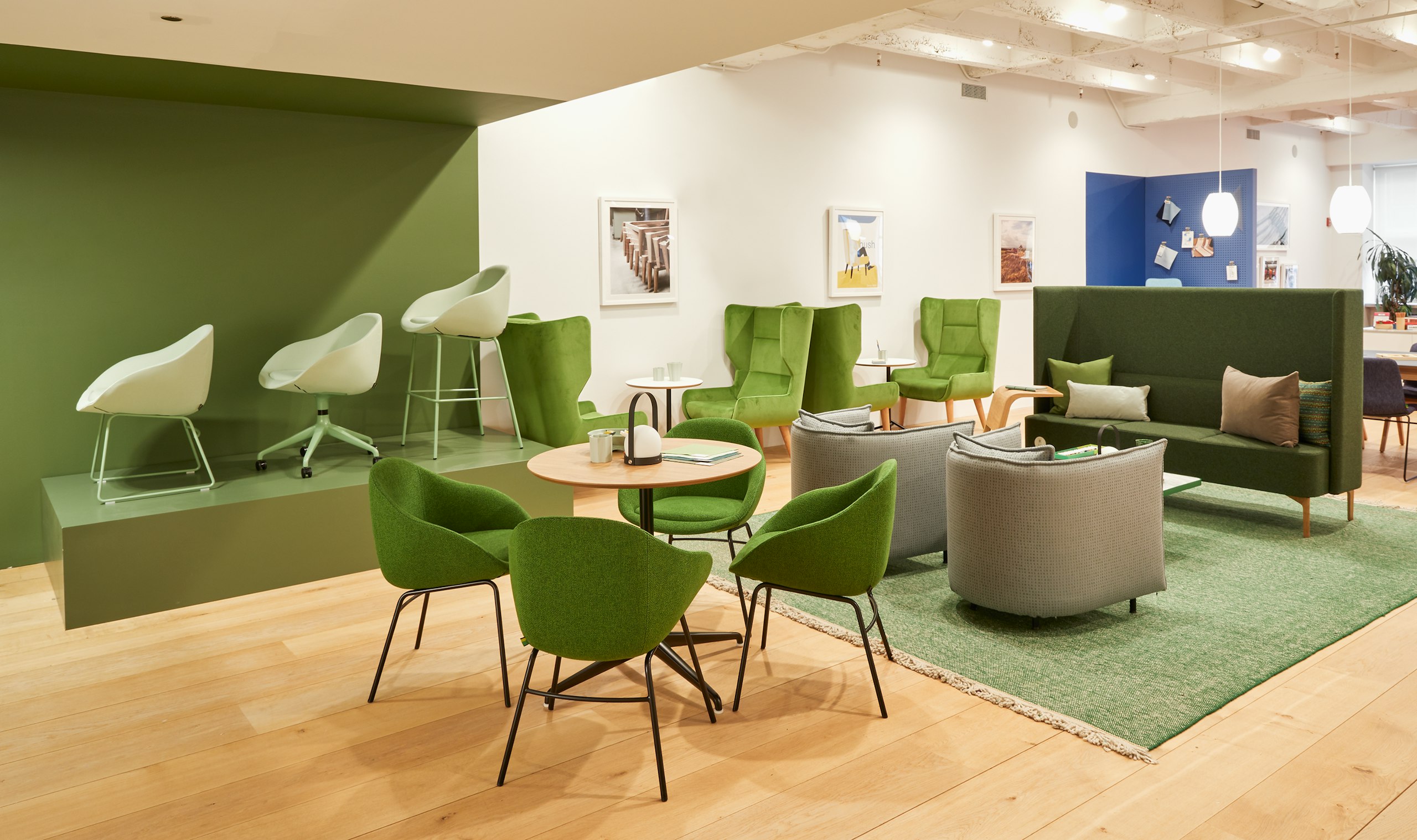 A display of green Always chairs with 4 leg bases, around an Ali Café Table, Cloud arm chairs and Pullman Sofa.
