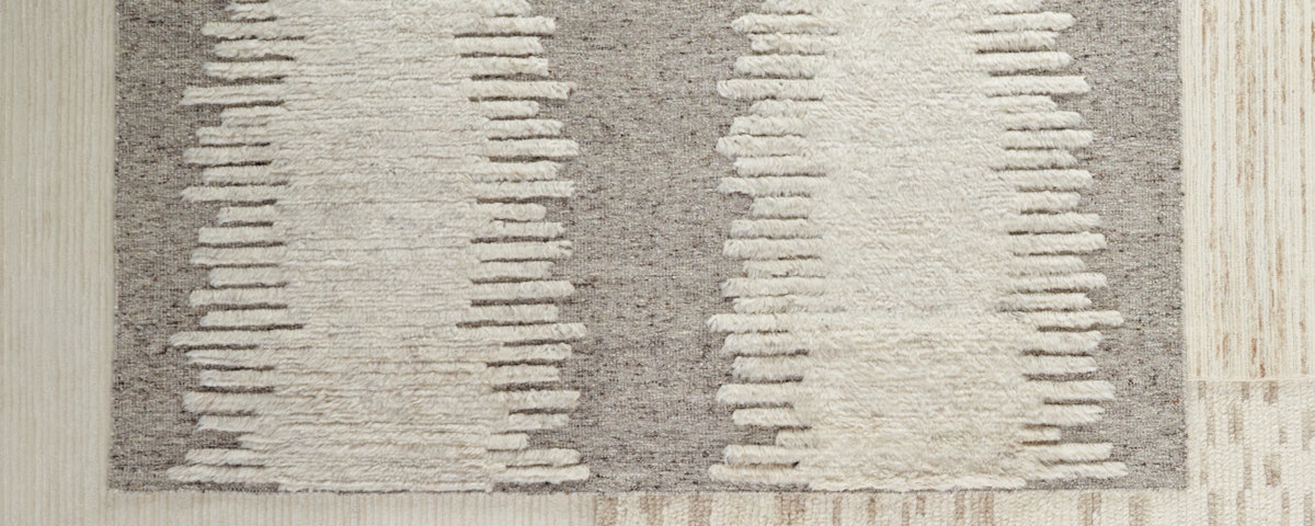 Dor Moroccan Wool Rug layered atop an assortment of other rugs
