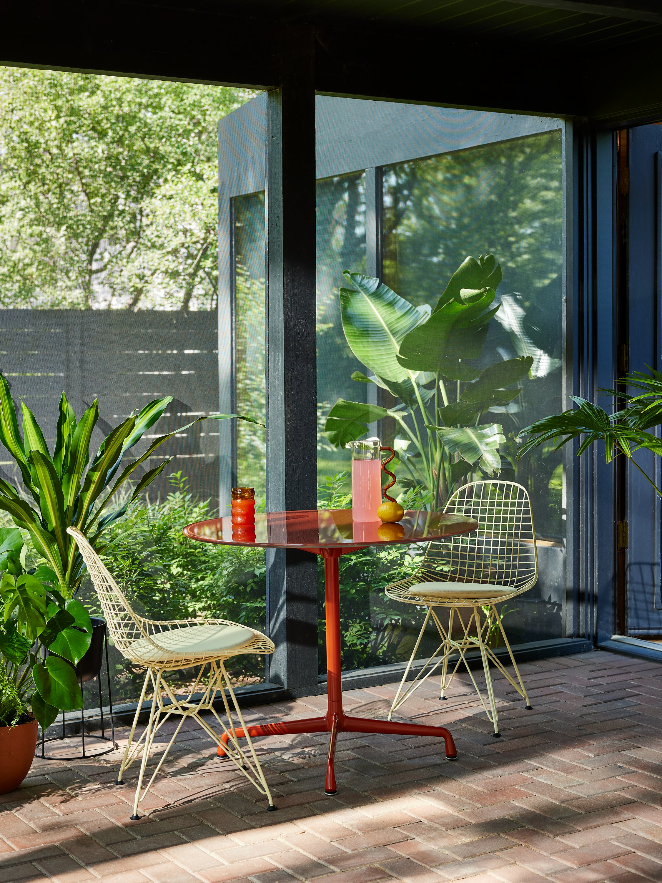 Herman Miller x HAY, outdoor setting of yellow Eames Wire Chair and red Eames table