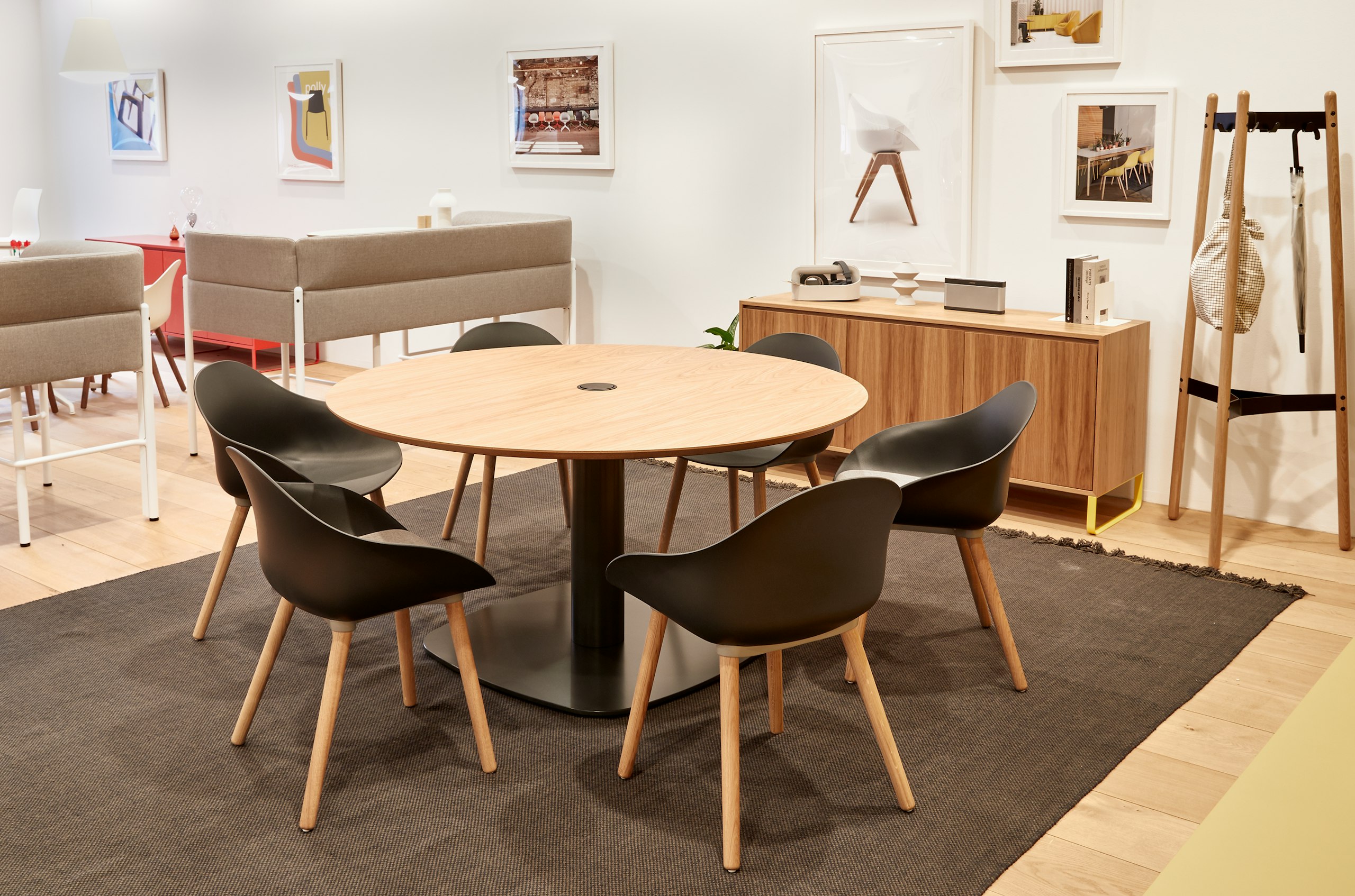 Six black Ruby chairs with oak dowel legs around a Megaped Table, with an oak veneer Sideboard and oak Hudson Coat Stand.