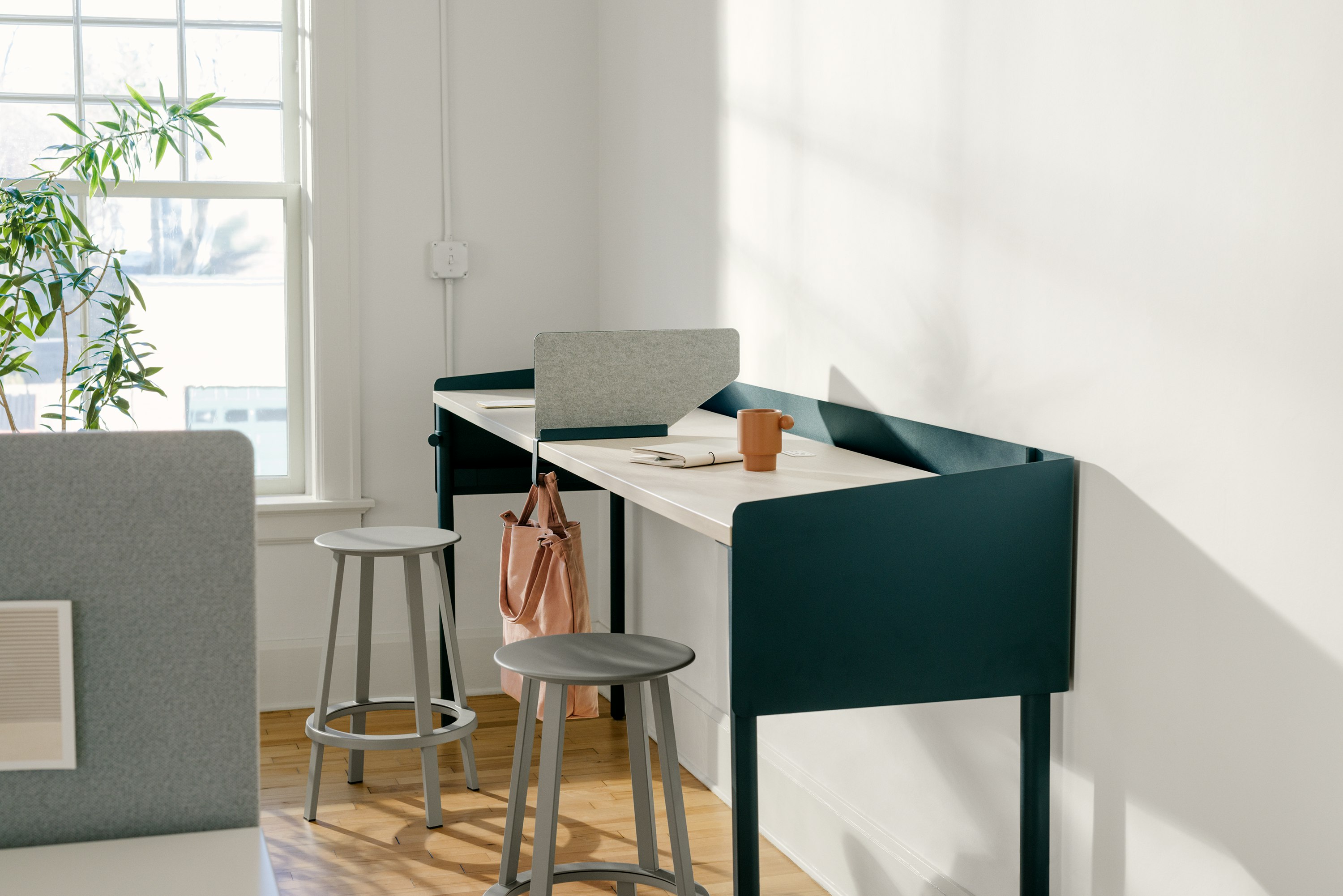 Blue single sided OE1 Communal Table with light brown surface, OE1 Boundary Screen and two grey Revolver Stools.