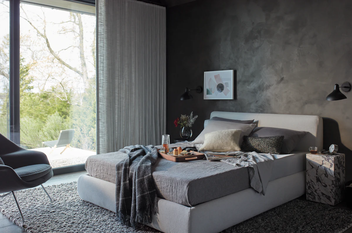 Neutral upholstered bed with white linens and beige headboard