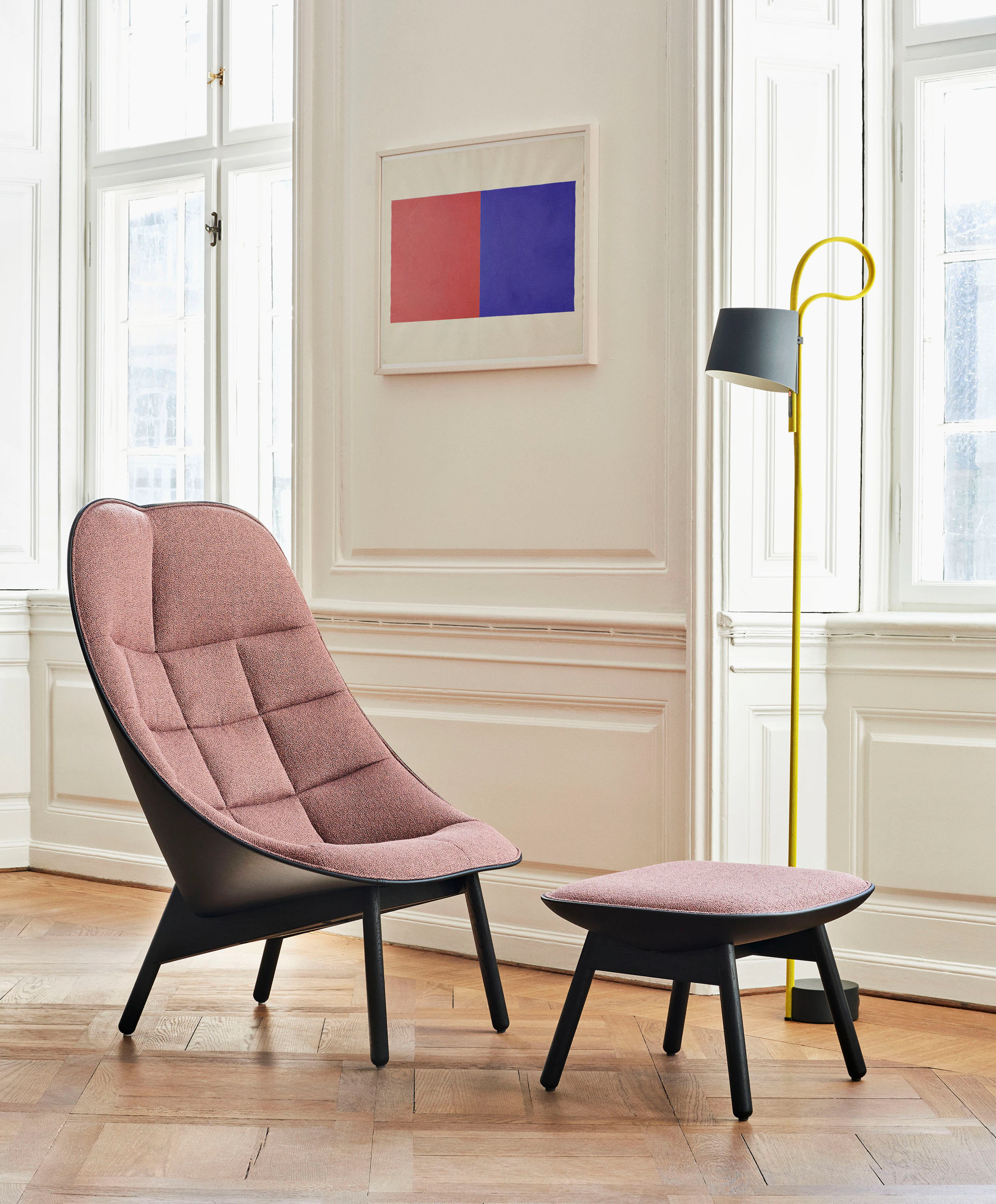 A Ochiwa Lounge Chair and Ottoman with red fabric and black base next to a window.