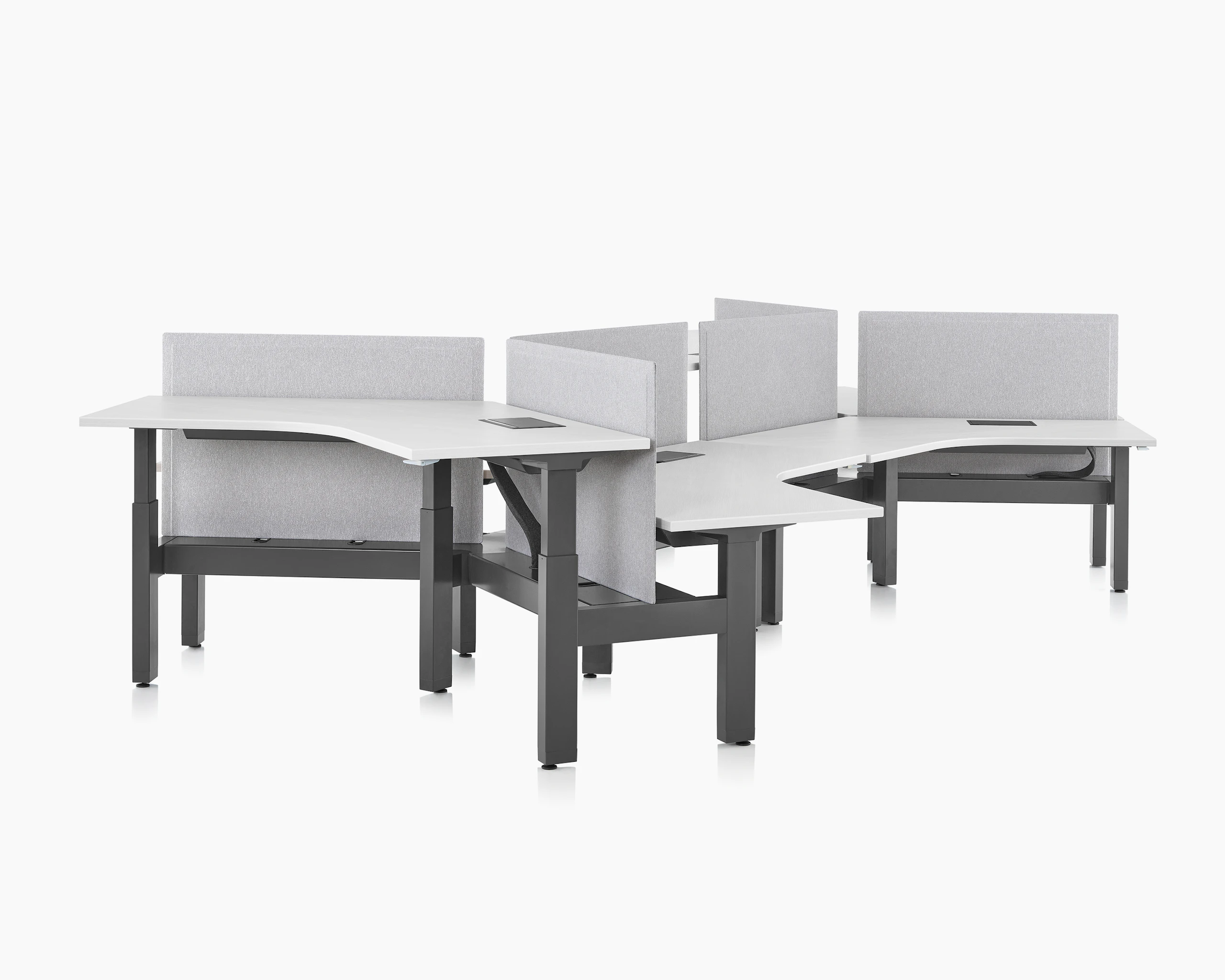 Standing desk system, Renew Link, with white 120-degree work surfaces, black base, and screens. Two of the six desks are raised at a standing height.