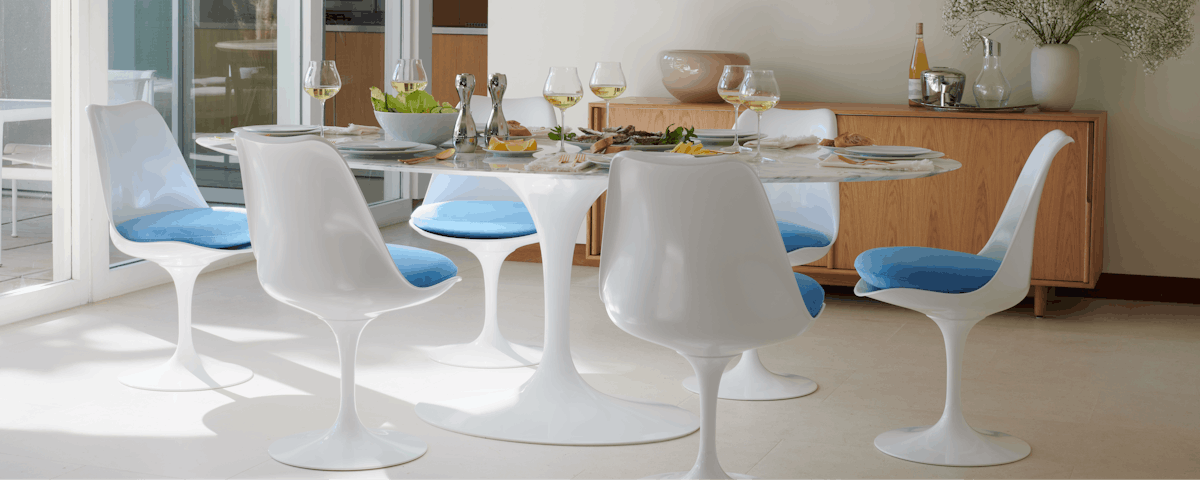Four Saarinen Tulip Side Chairs surrounding a Saarinen Dining Table in a dining room setting