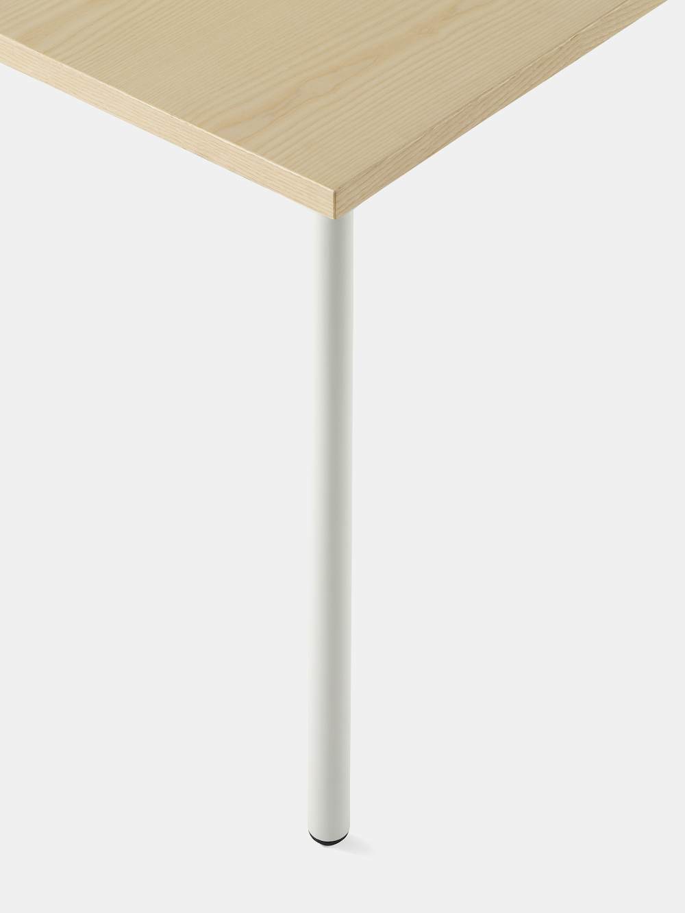 OE1 Rectangular Table with light brown surface and white legs with an up close view of the rounded leg.