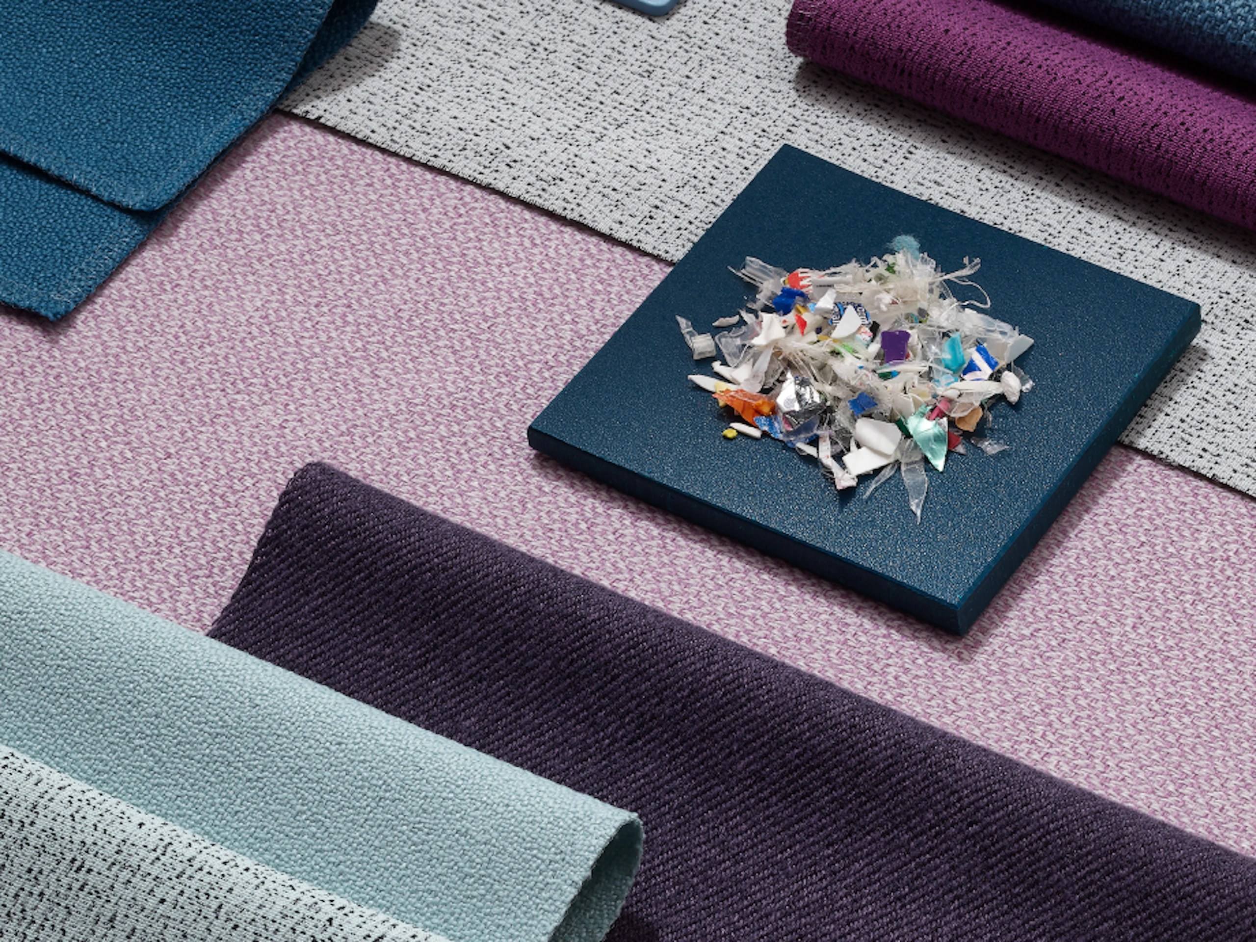 A pile of small plastics on top of a variety of textile samples.