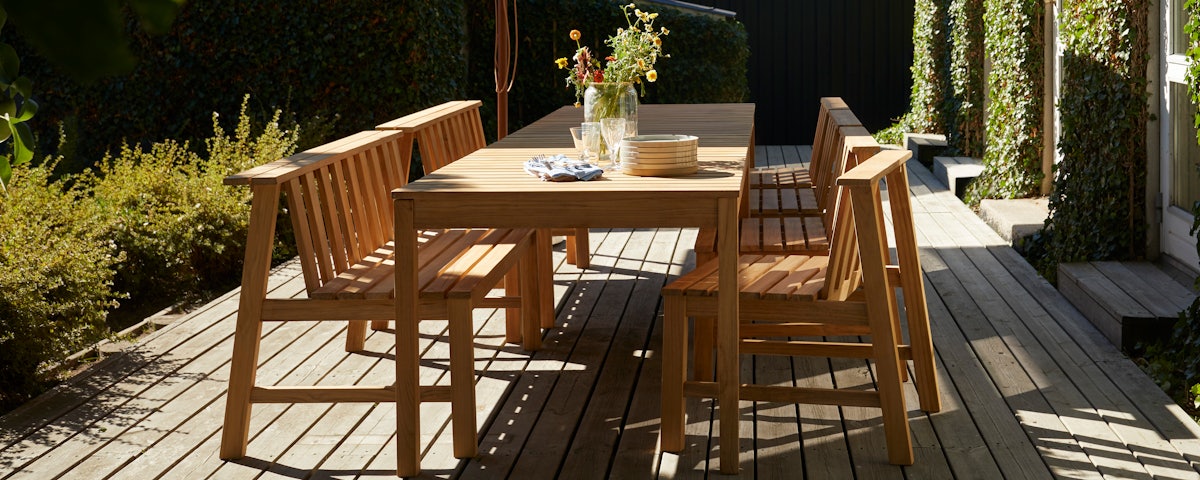 Plank Bench and Plant Chairs surrounding a Plank Table in a outdoor deck setting
