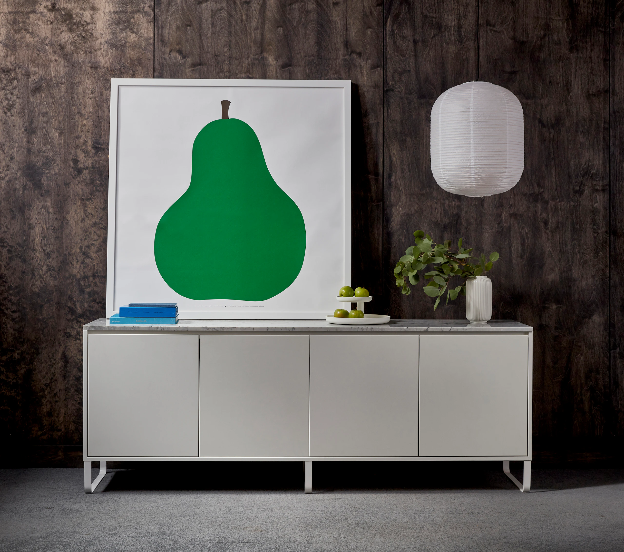 White Sideboard with painting of a Pear sitting on top of the marble surface.