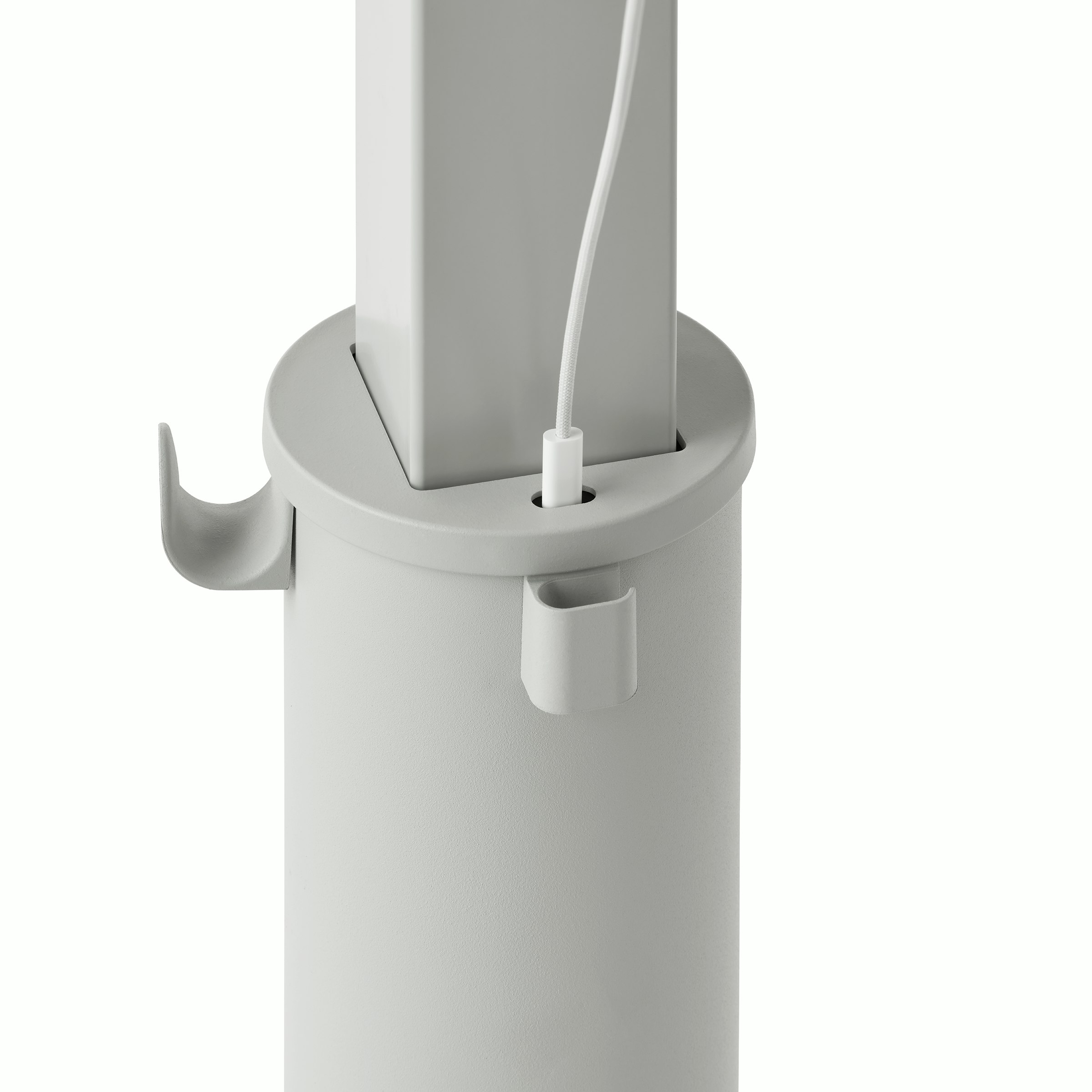 Detail of a grey OE1 Sit-to-Stand Table column with USB-C port with cable plugged in, and a bag hook and cable management clip.