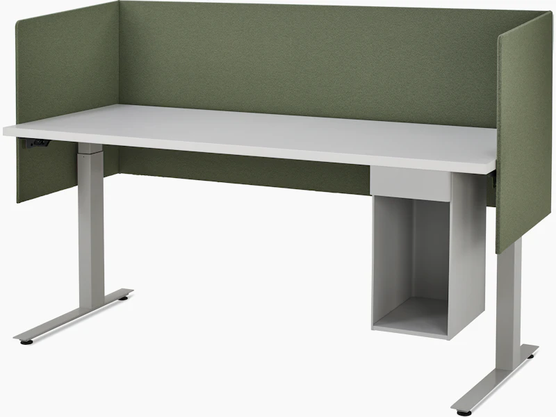 Large, grey metal suspended storage attached to bottom of laminate worksurface of height adjustable table with three sided olive fabric screen.