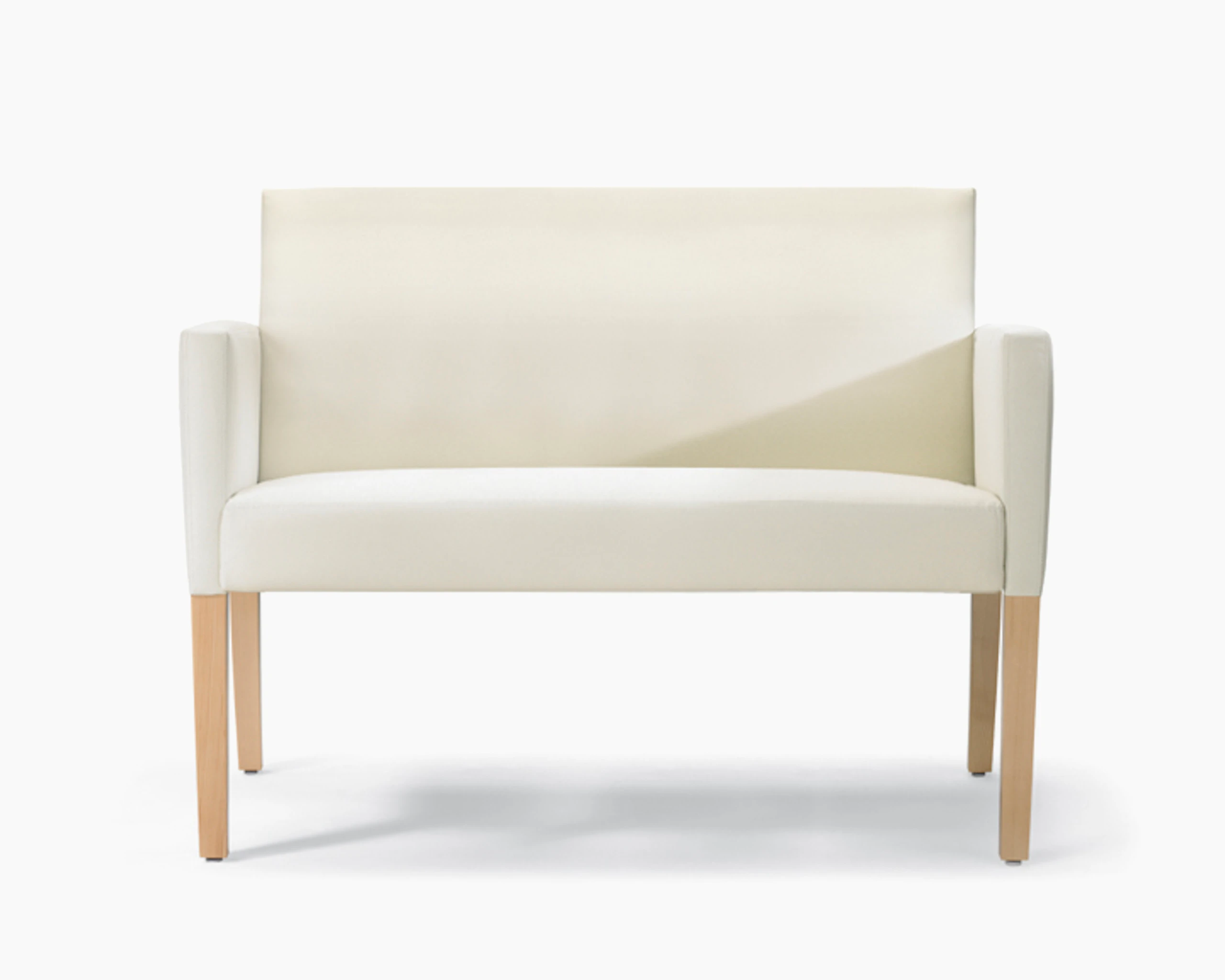 A front view of a Brava 862 plus chair in white textile with upholstered arms and maple legs.