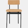 A cork Betwixt Chair with a black frame.