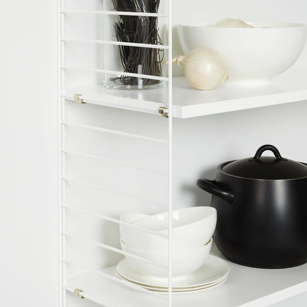 White metal shelving unit with bowls and pot in kitchen setting