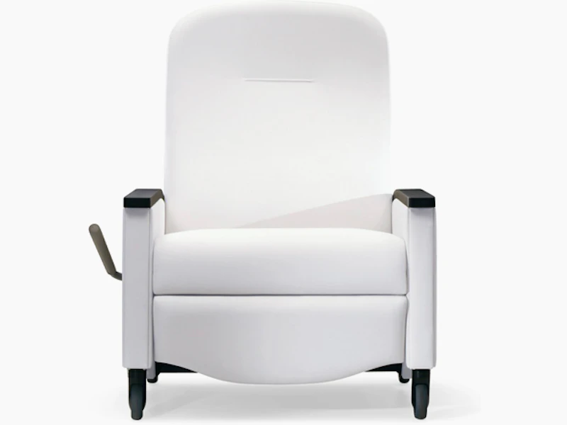 A front view of a PrÃsto Plus Recliner in a white upholstery with black urethane arm caps.
