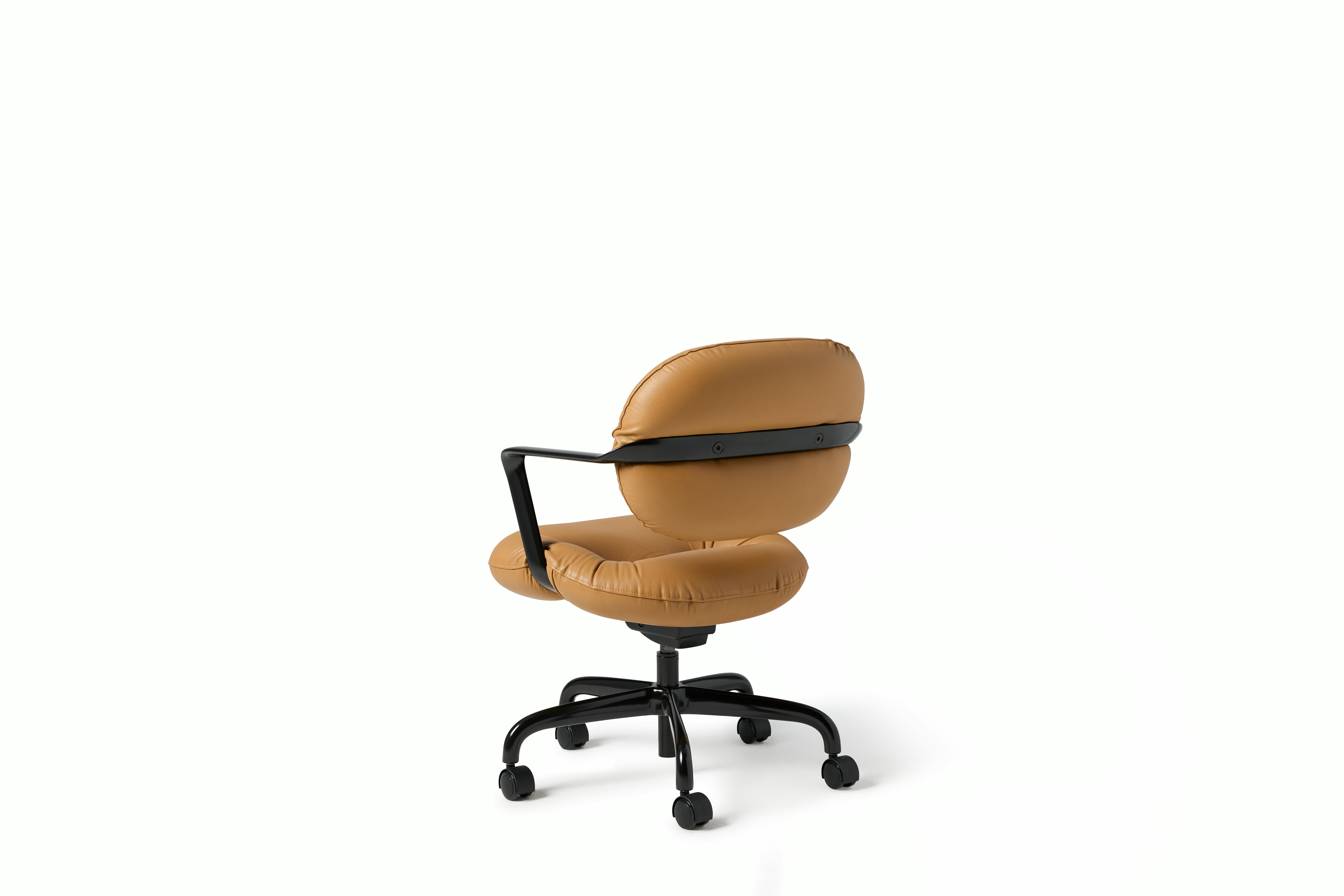 Rear angle view of a Morrison Hannah chair with a black frame and base with fixed arms and light brown leather upholstery.
