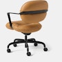 Rear angle view of a Morrison Hannah chair with a black frame and base with fixed arms and light brown leather upholstery.