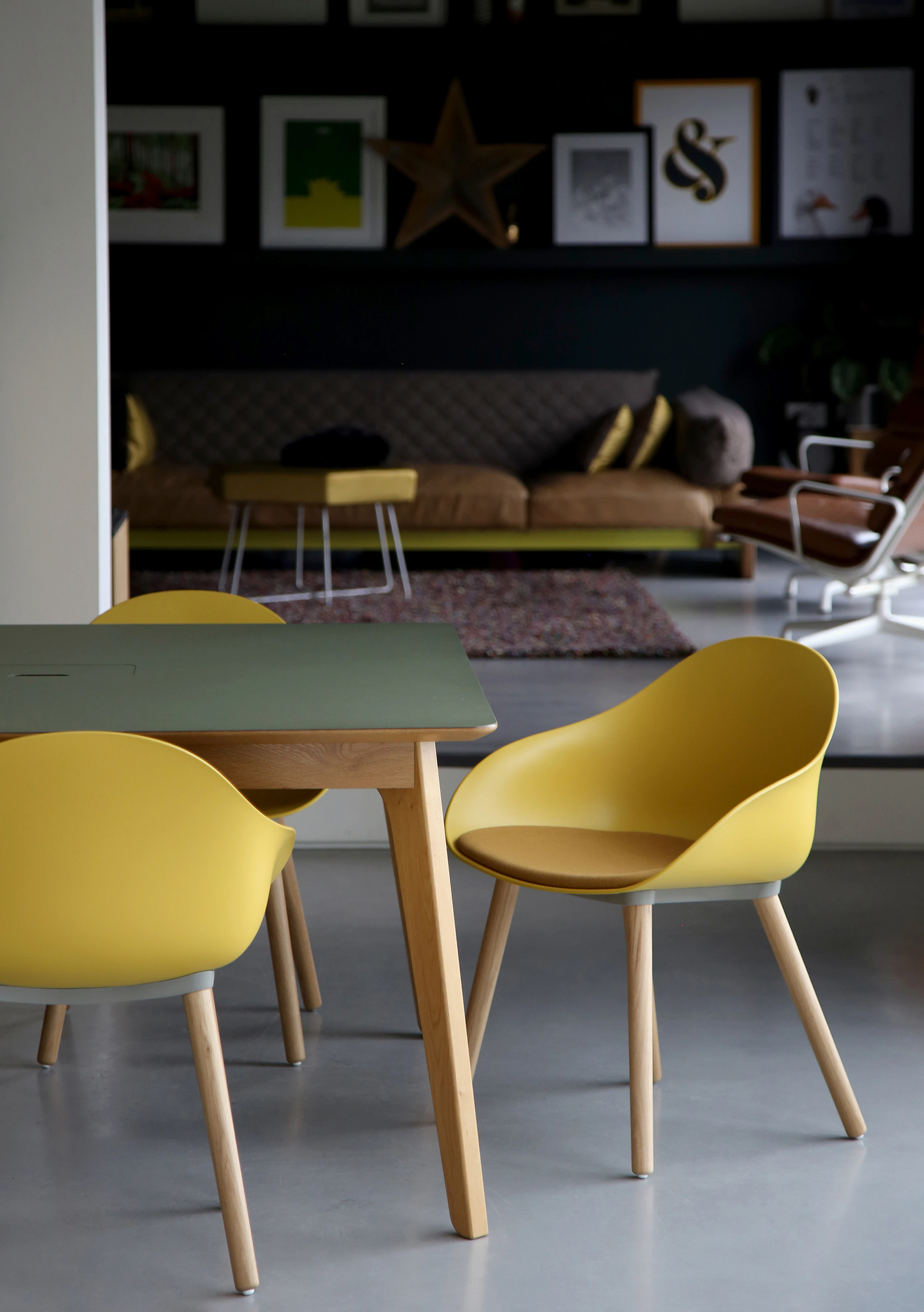 Three yellow Ruby Side Chairs on oak dowel bases with a table.