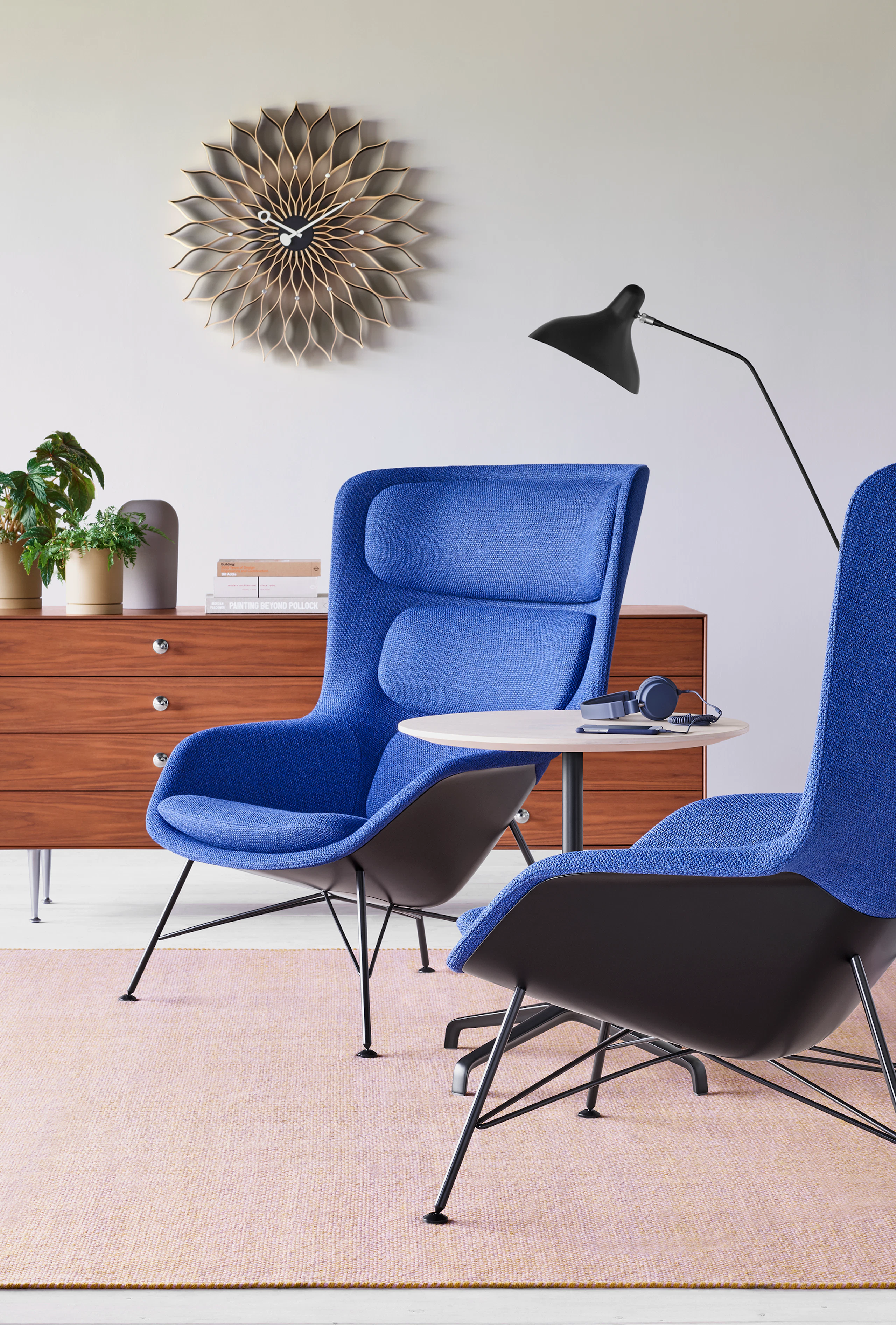 Two blue Striad Lounge Chairs aside a small Striad Table with a white ash top.