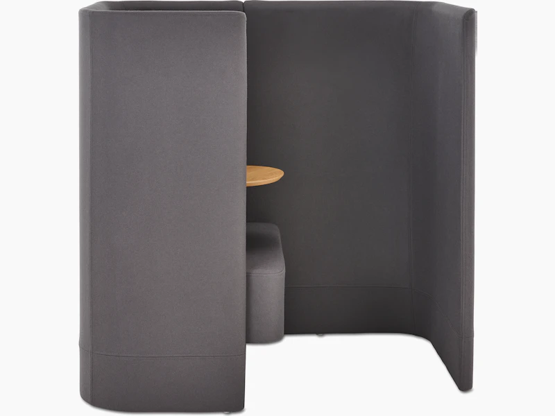 Whitesweep shot of Pullman Chair Pod upholstered in dark grey fabric, with tablet arm and screen left.