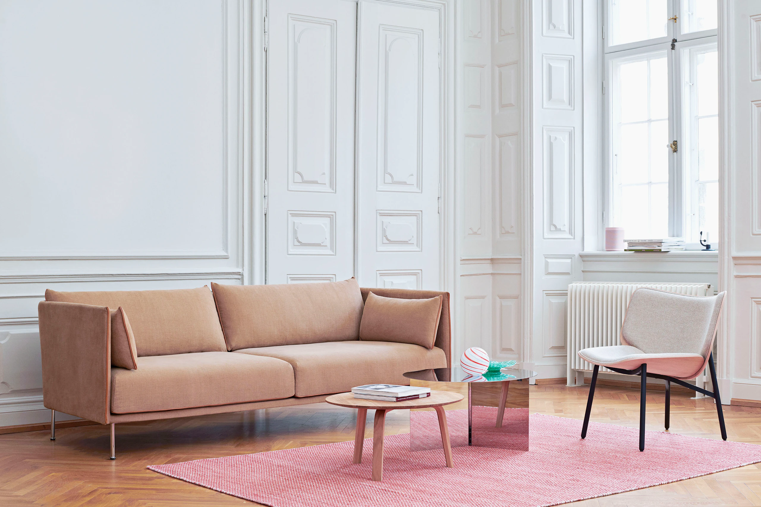 A grey Dapper Lounge Chair next to a Silhouette Sofa.