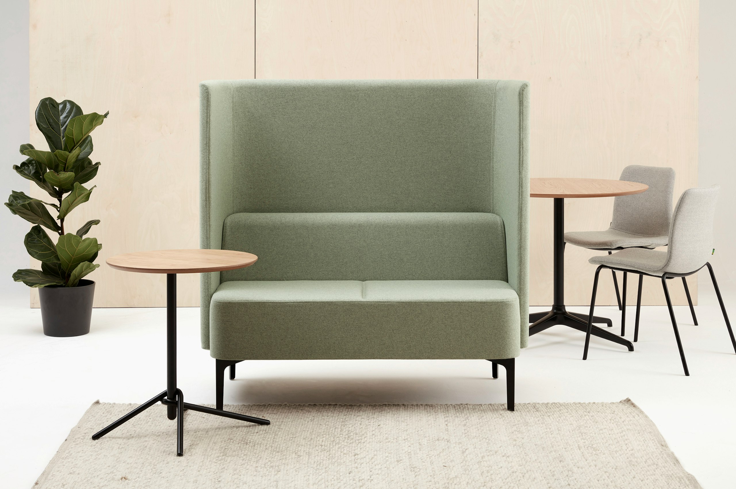 2 seat high back Pullman Sofa upholstered in pale green fabric with black steel legs, with side table and two Viv Side Chairs.