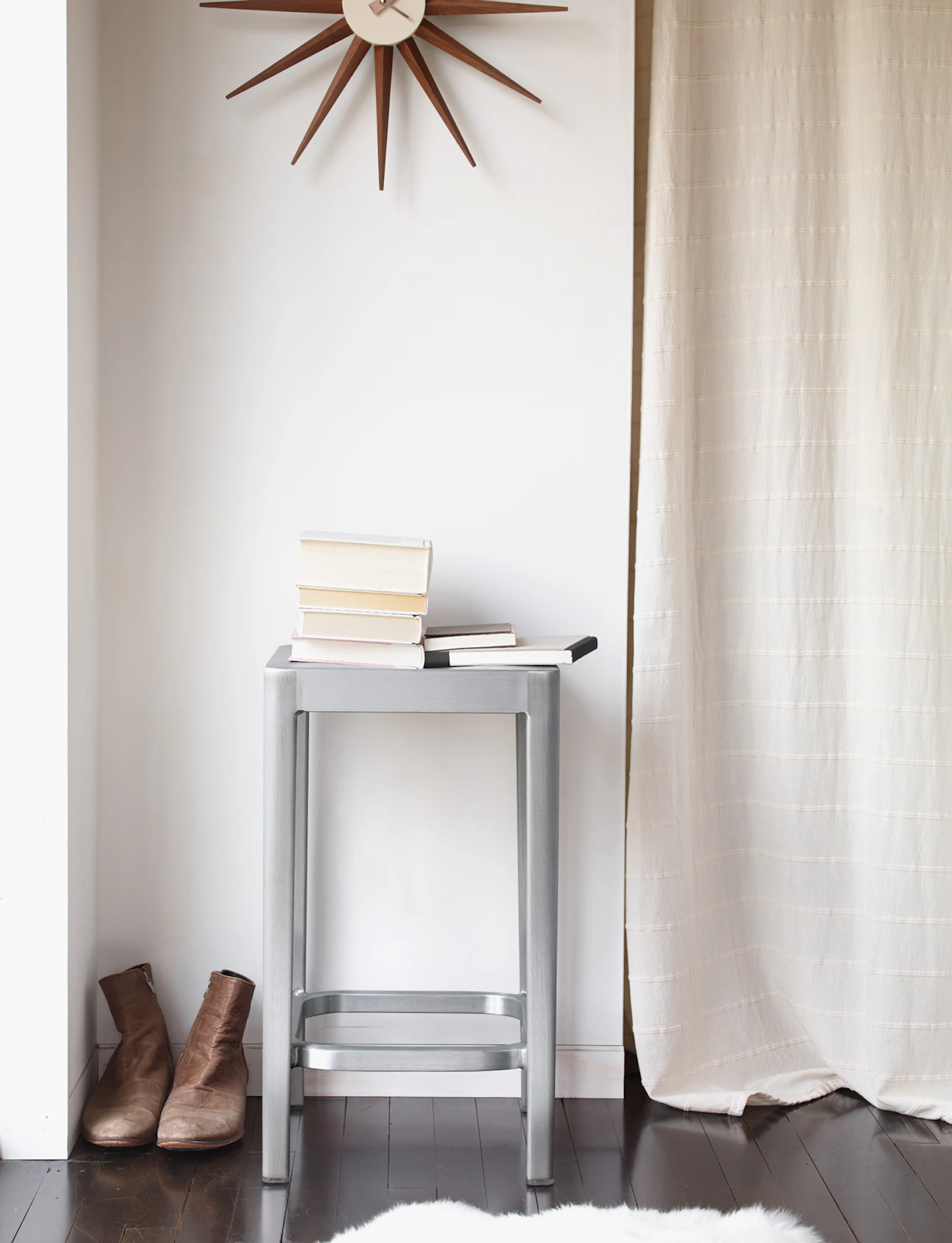 Emeco stool used as a step with a light-colored top and silver metal frame