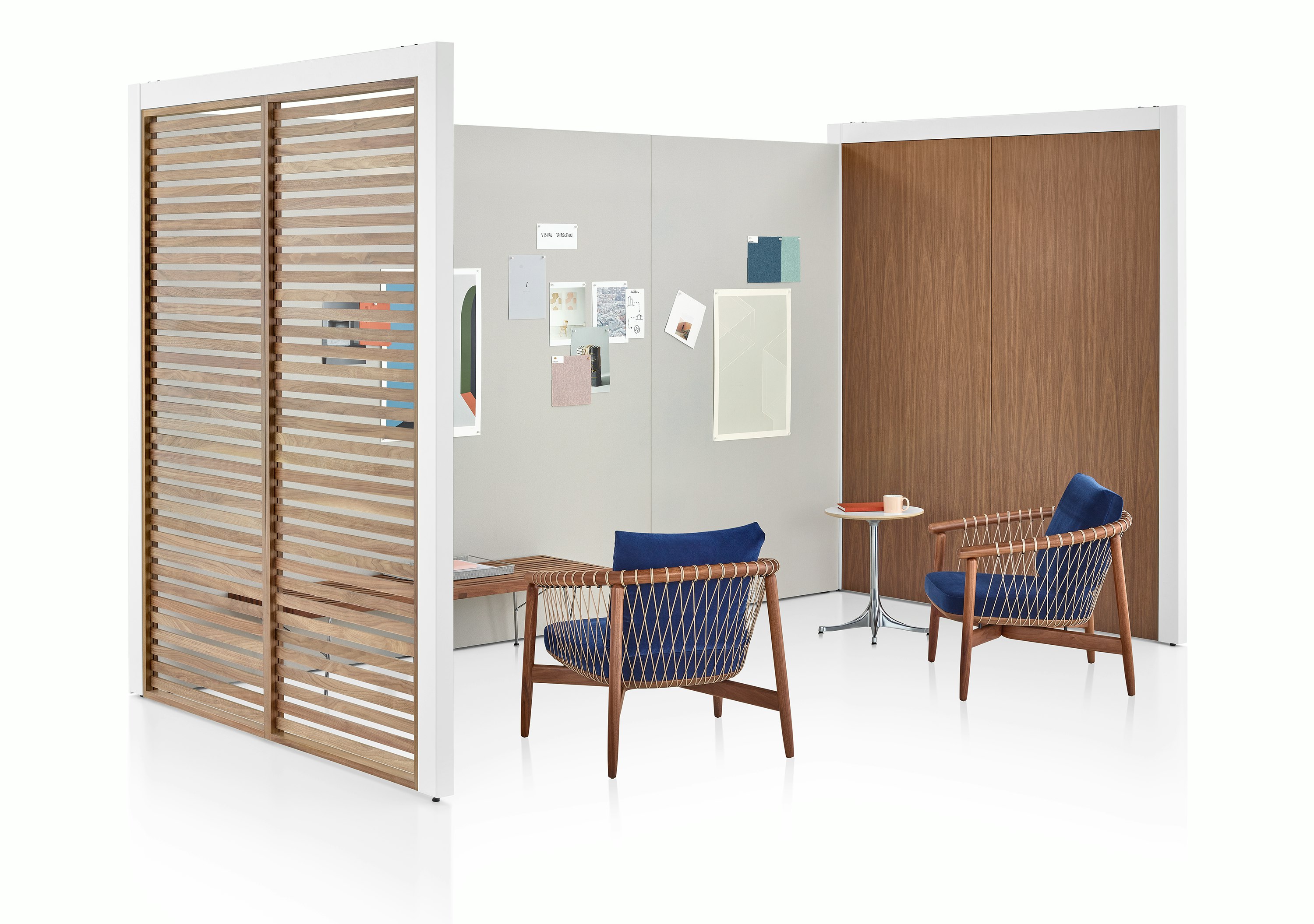 A three-sided Overlay space with walnut wood slats, walnut laminate, and gray tackable fabric walls with two chairs and a bench inside.