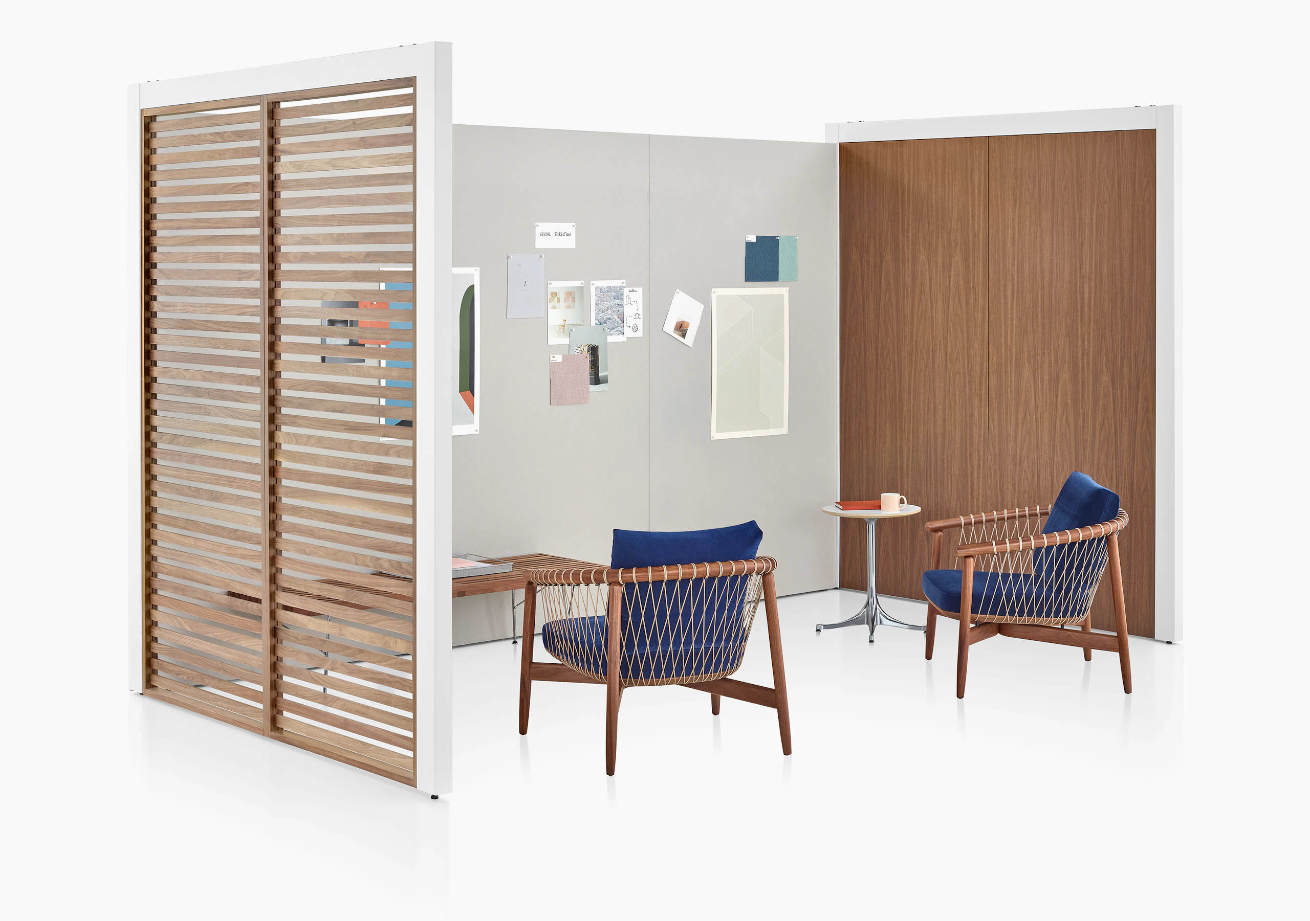 A three-sided Overlay space with walnut wood slats, walnut laminate, and gray tackable fabric walls with two chairs and a bench inside.