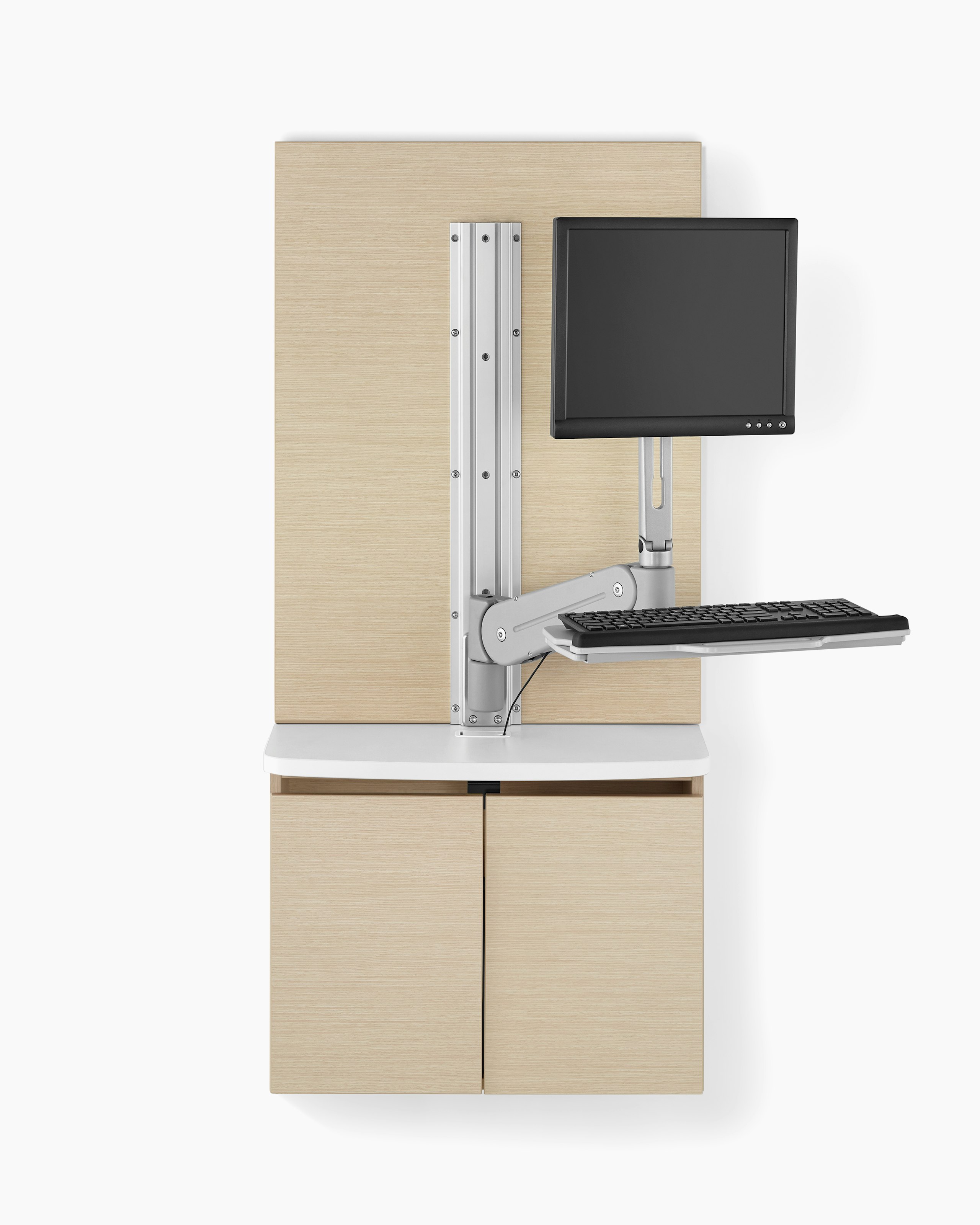 A Mora Systems casework technology cabinet in an ash finish with a white solid surface top, and an MBrace monitor and keyboard support attached to it.
