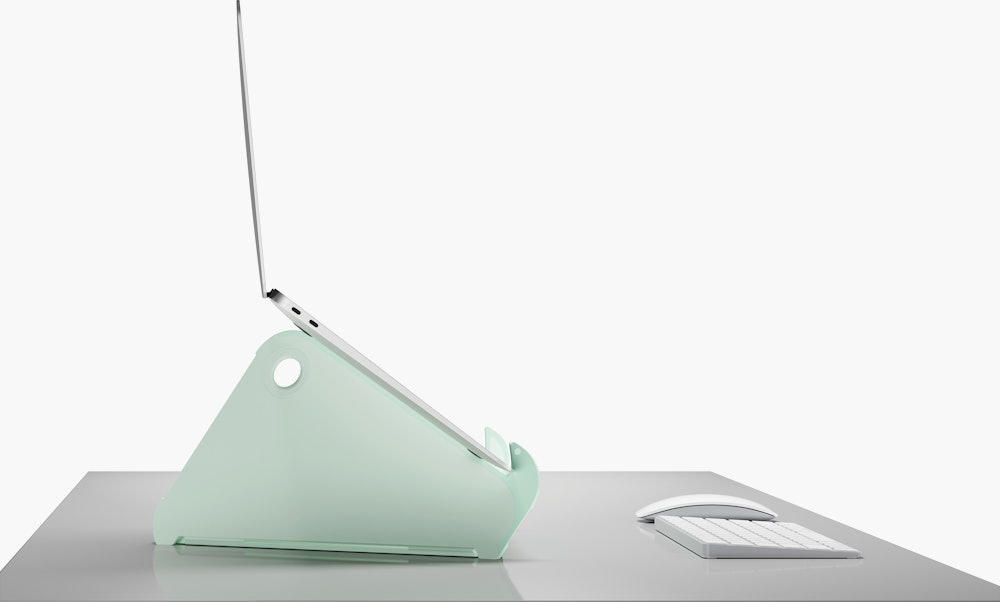 Side profile of an open and raised laptop on an Oripura Laptop Stand in mint green.