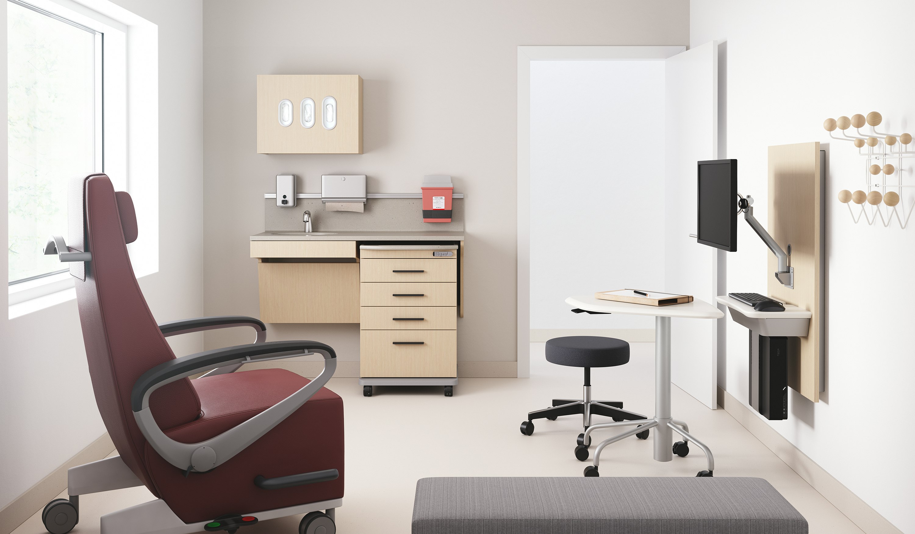 An exam room with Mora casework in an ash wood finish including a supply cart, Intent Solution in an ash finish, a physician's stool in dark gray, a Ava recliner in a maroon upholstery, and a Riva bench in gray.