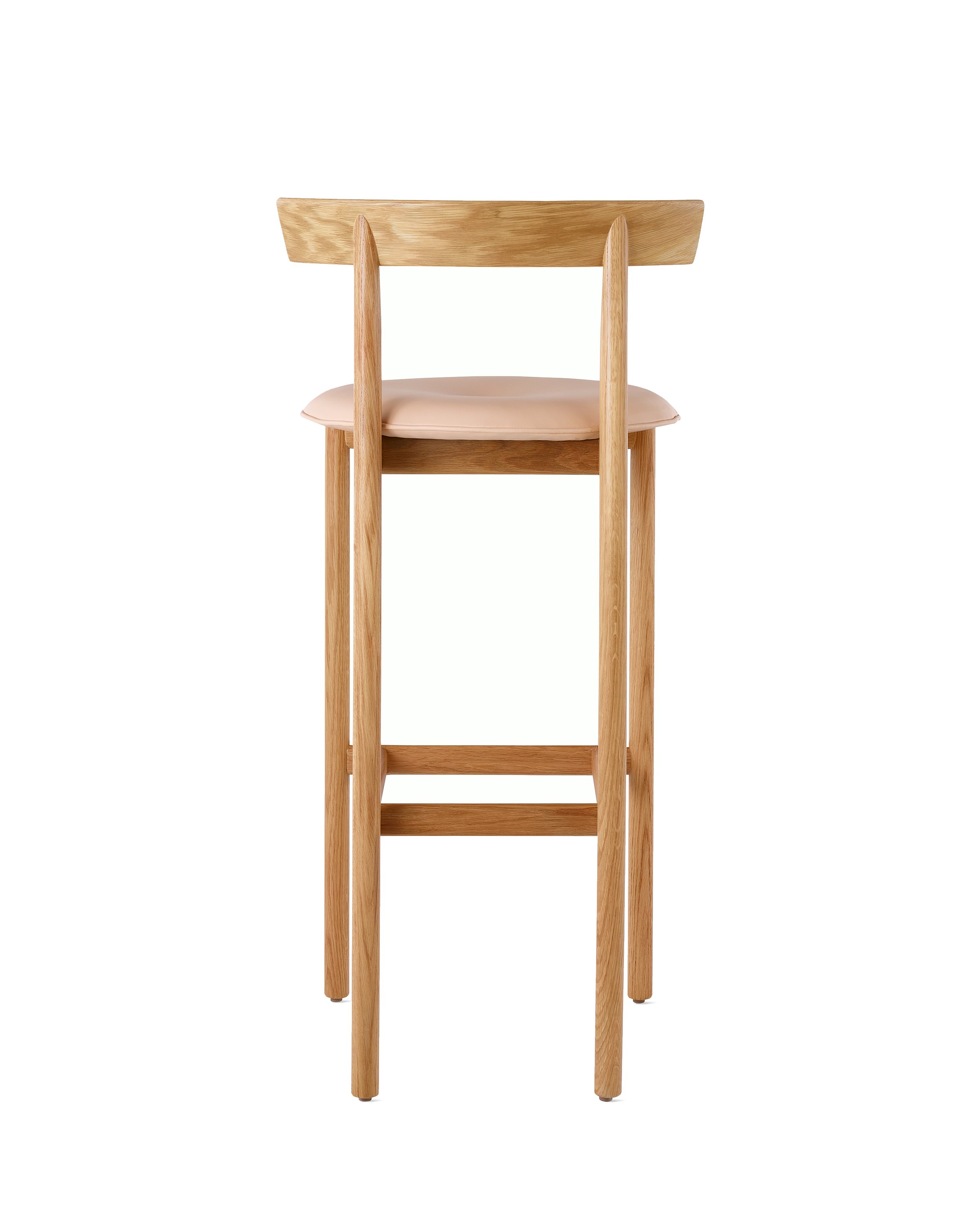 An oak bar-height Comma Stool with a seat pad, viewed from the back.