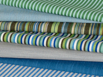 A variety of different textiles folded on top of one another.